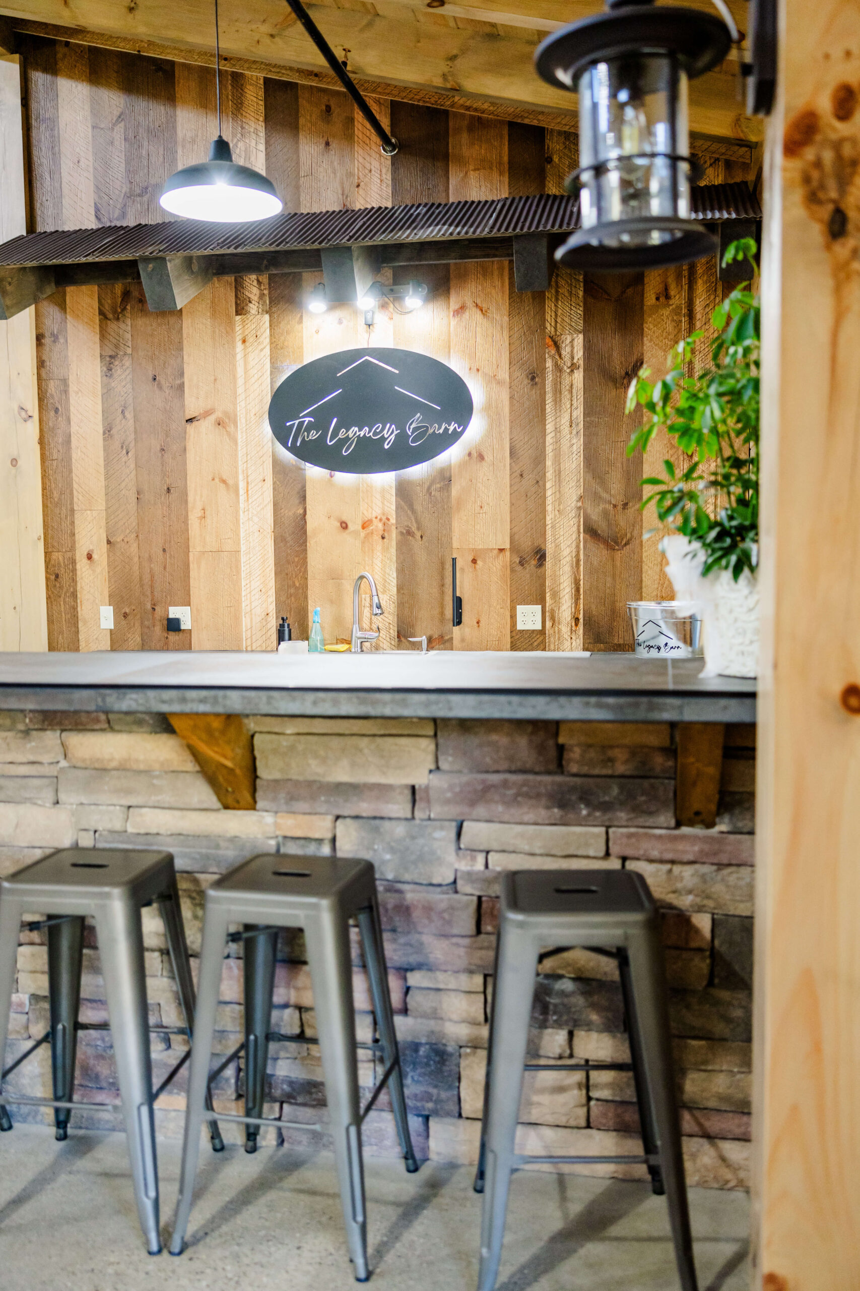 Details of The Legacy Barn sign lit up behind the bar