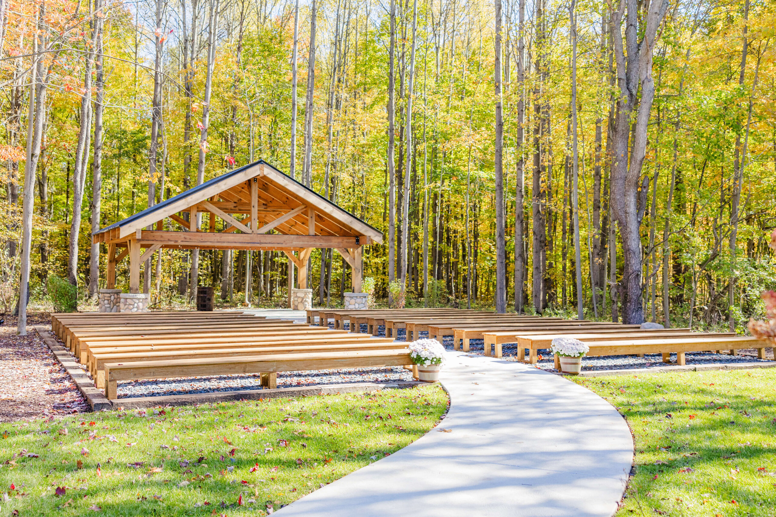 A look at the beautiful outdoor ceremony location with wooden benches at The Legacy Barn