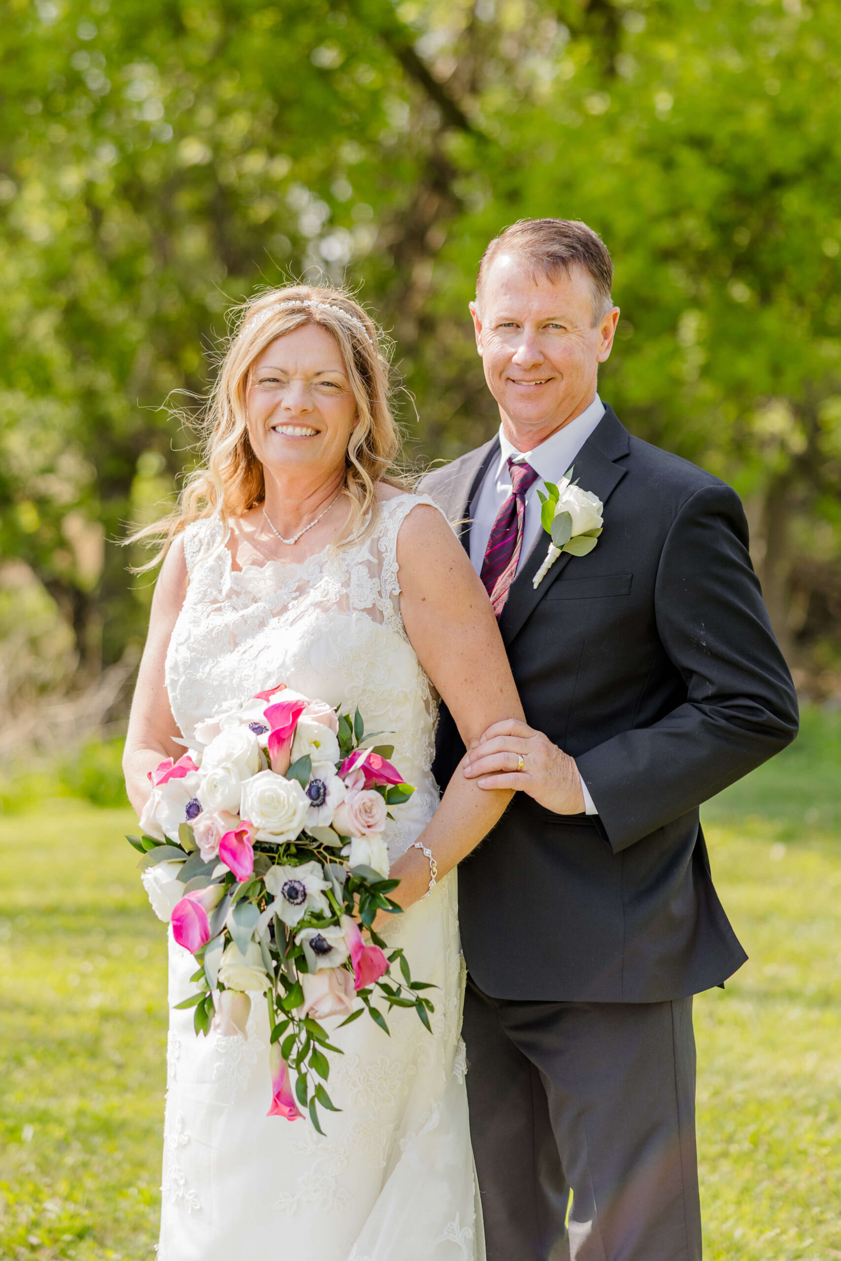 A happy newlywed couple stands together in a field at Trillium farm events