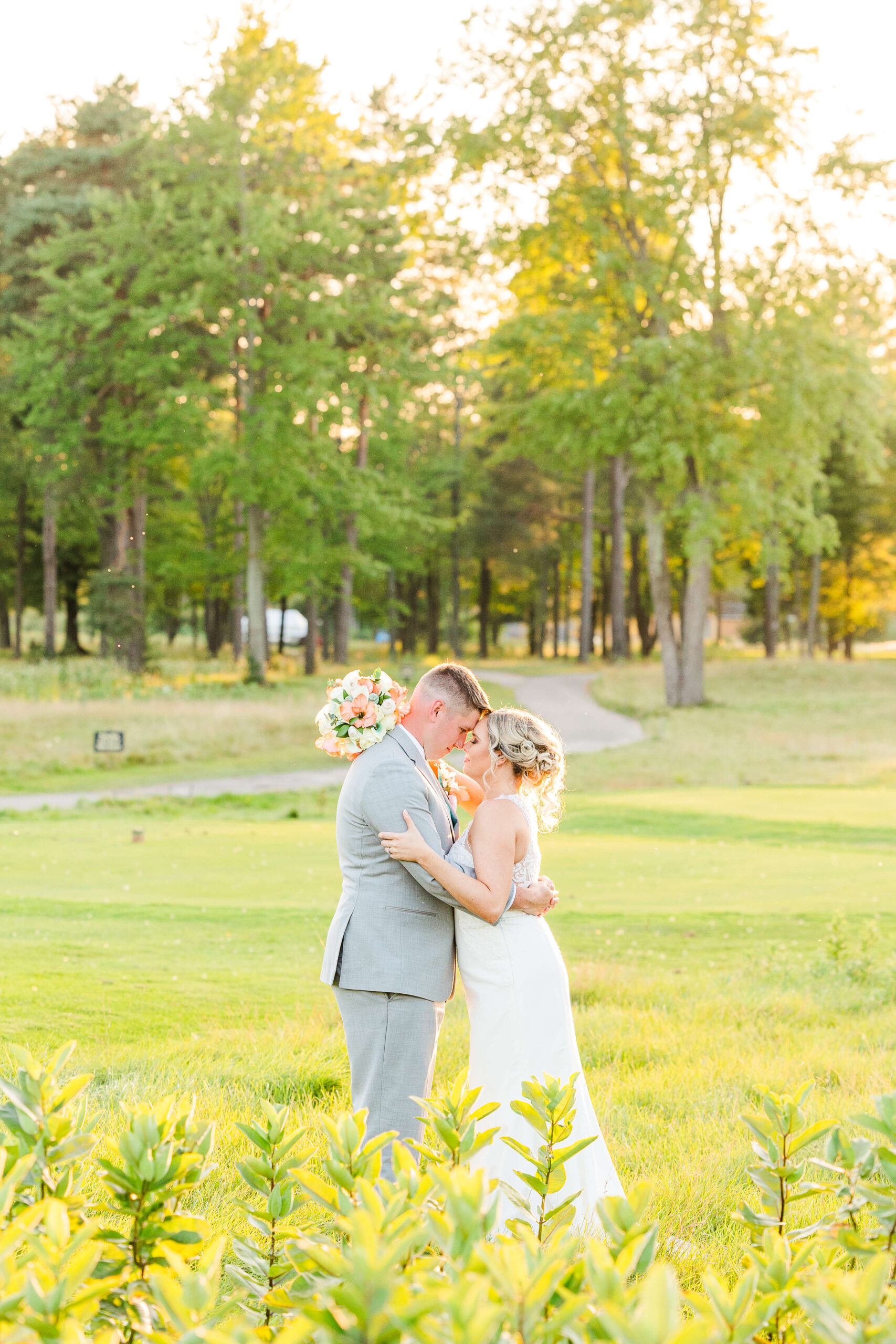 Newlyweds embrace and touch foreheads while the sun sets