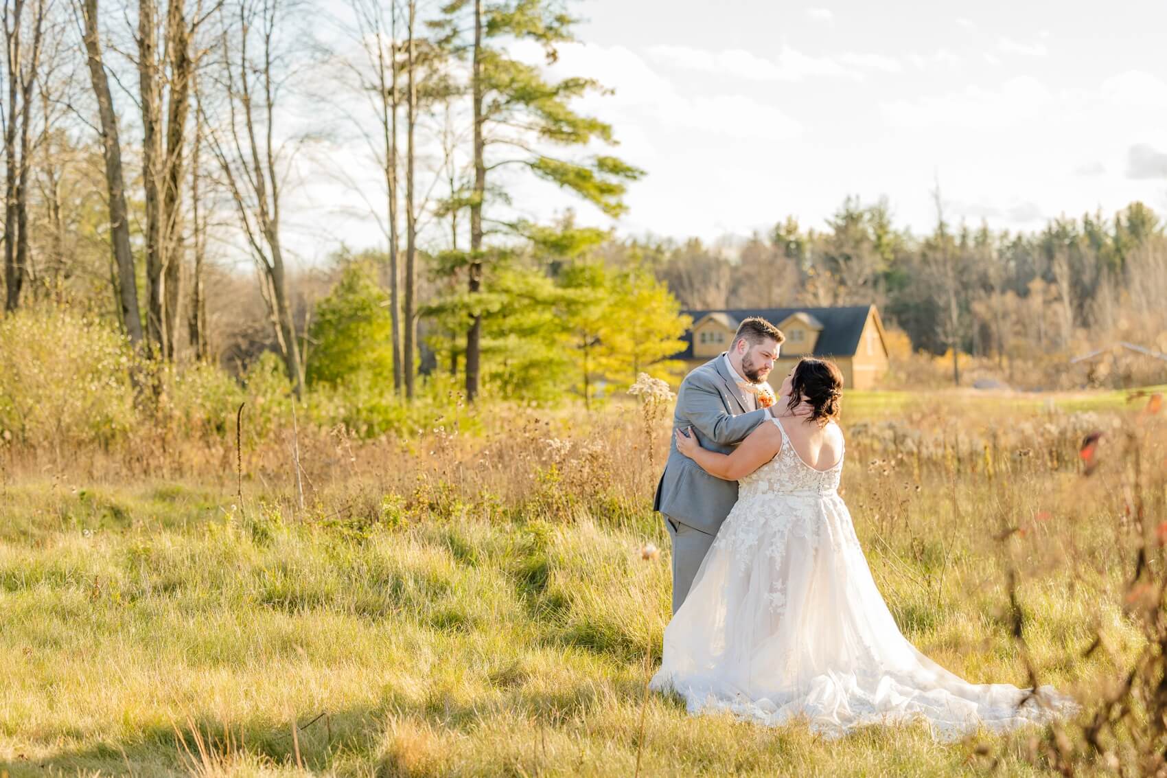 A bride and groom share an intimate moment in a field of tall grass at golden hour during their solitude links wedding