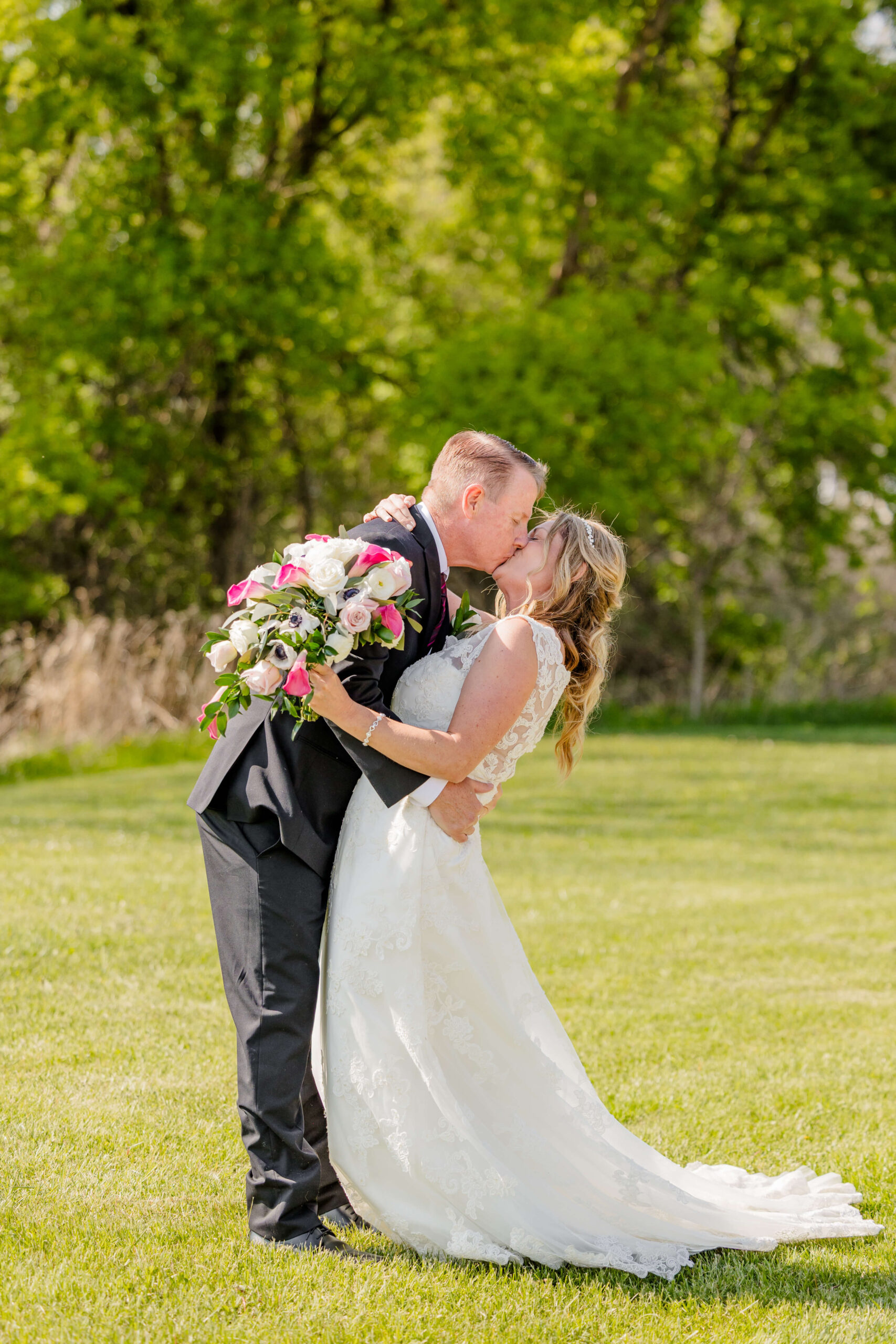 A bride and groom kiss and dip in the manicured lawn of the verona hills golf club wedding venue
