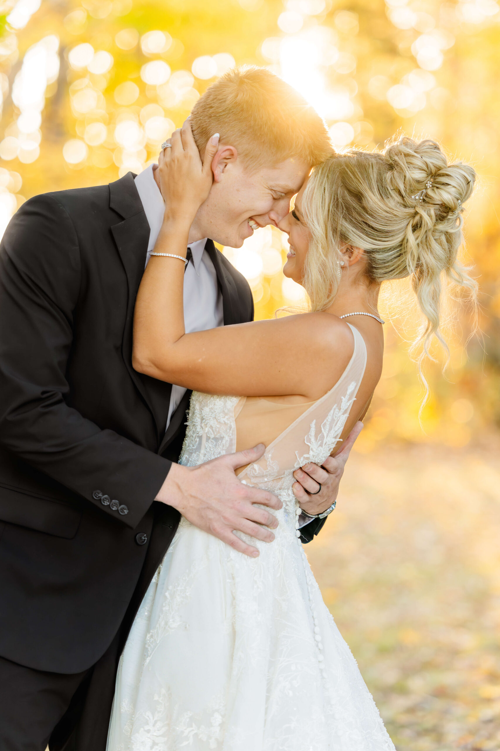 A bride and groom laugh while leaning in for a happy kiss at sunset during their zingerman's cornman farms wedding