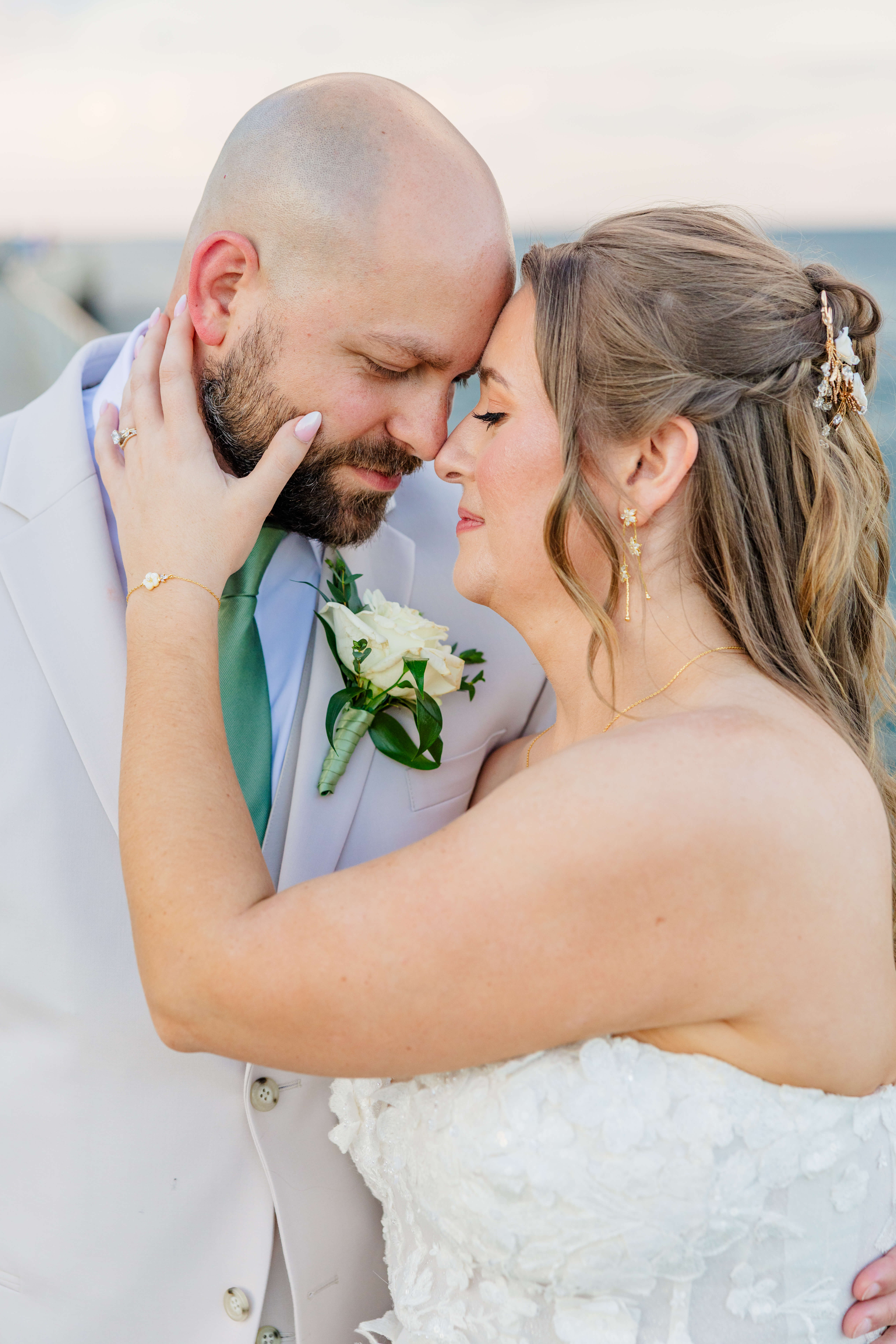 Newlyweds snuggle foreheads in grey and lace at sunset with a hand on his neck during their oakhurst country club wedding